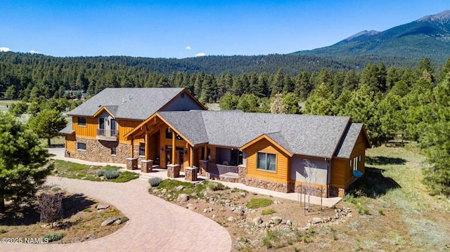 9178 N Snowbowl Ranch Rd, Flagstaff, AZ 86001 - view of front of house with stone siding, a forest view, and a porch