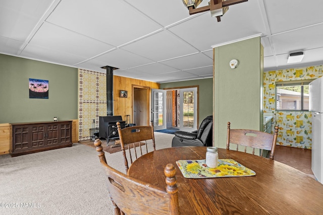 5735 White Tail Ln, Flagstaff, AZ 86005 - dining room with a wood stove, a drop ceiling, wood walls, and carpet flooring
