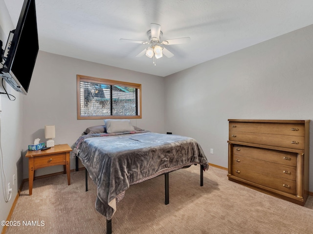 bedroom featuring baseboards, light colored carpet, and ceiling fan