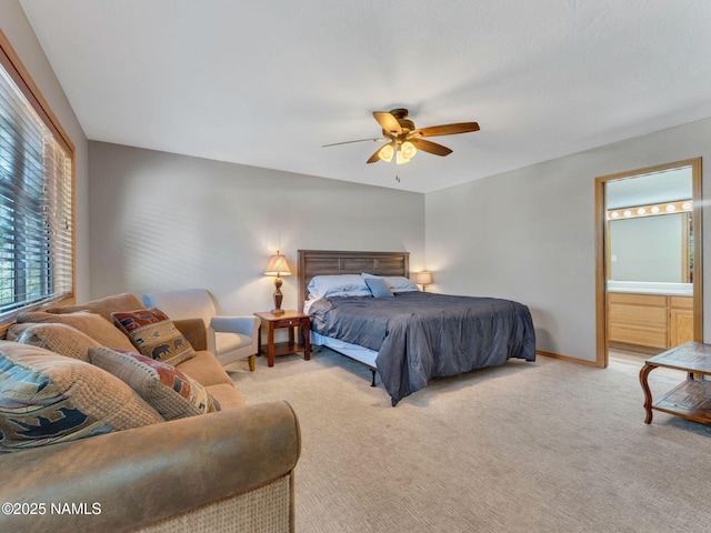 carpeted bedroom with connected bathroom, baseboards, and ceiling fan