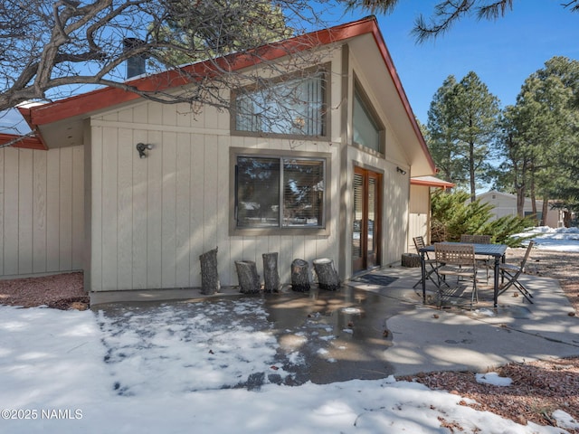 snow covered property with a patio area