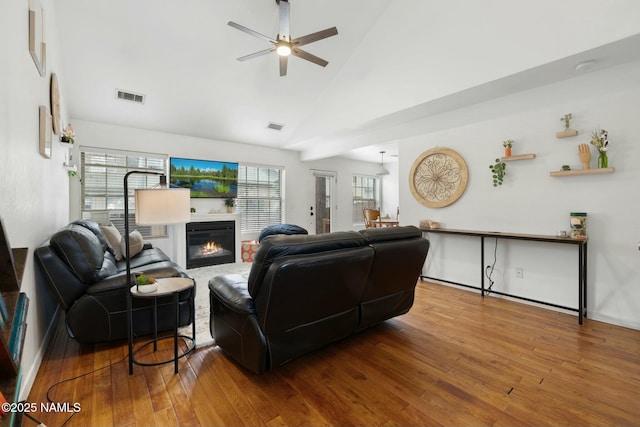 2548 S Gravel Ln, Flagstaff, AZ 86001 - living area featuring ceiling fan, a glass covered fireplace, vaulted ceiling, visible vents, and wood finished floors