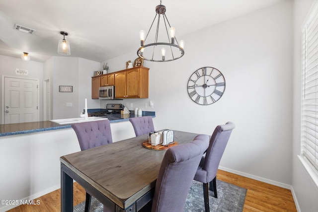 9119 W Arden Ln, Bellemont, AZ 86015 - dining room featuring visible vents, baseboards, plenty of natural light, a chandelier, and light wood finished floors