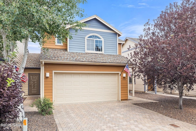 9119 W Arden Ln, Bellemont, AZ 86015 - traditional-style house with an attached garage, roof with shingles, and decorative driveway