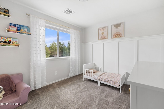 9119 W Arden Ln, Bellemont, AZ 86015 - carpeted bedroom featuring a decorative wall, visible vents, and a wainscoted wall
