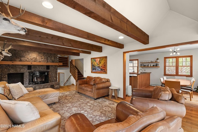 3480 S Moore Cir, Flagstaff, AZ 86005 - living area with stairway, wood finished floors, a chandelier, a stone fireplace, and beamed ceiling