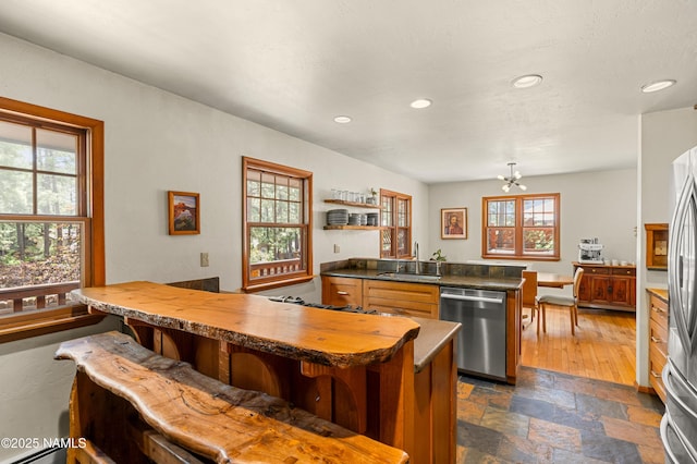 3480 S Moore Cir, Flagstaff, AZ 86005 - kitchen with stainless steel appliances, recessed lighting, a kitchen bar, dark stone finish flooring, and a chandelier