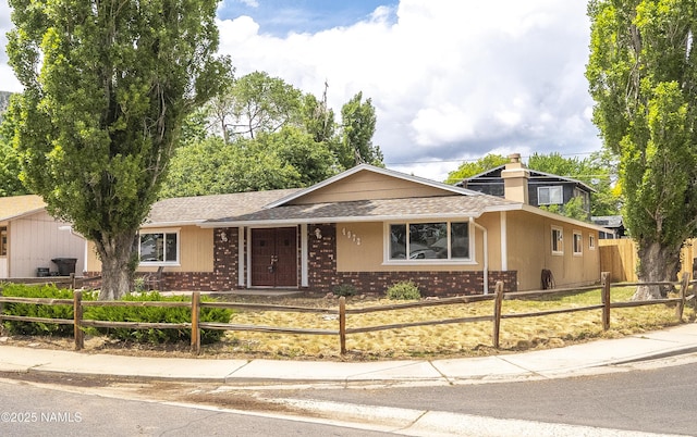 4972 E Snow Shoe Way, Flagstaff, AZ 86004 - ranch-style house featuring brick siding, a fenced front yard, and a chimney
