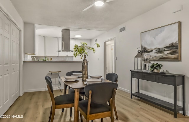 4972 E Snow Shoe Way, Flagstaff, AZ 86004 - dining area with light wood finished floors, a ceiling fan, and baseboards