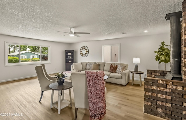 4972 E Snow Shoe Way, Flagstaff, AZ 86004 - living area featuring a ceiling fan, light wood-type flooring, a textured ceiling, and baseboards