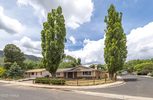 4972 E Snow Shoe Way, Flagstaff, AZ 86004 - single story home with a fenced front yard, a chimney, a garage, and a mountain view