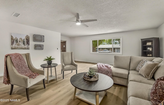 4972 E Snow Shoe Way, Flagstaff, AZ 86004 - living room with a ceiling fan, light wood finished floors, a textured ceiling, and baseboards