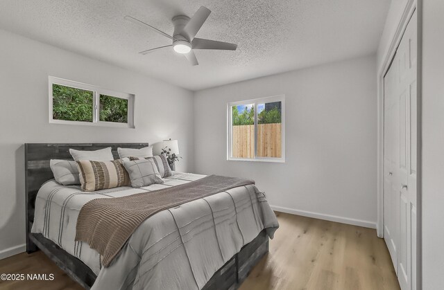 4972 E Snow Shoe Way, Flagstaff, AZ 86004 - bedroom with baseboards, a closet, a textured ceiling, wood finished floors, and ceiling fan