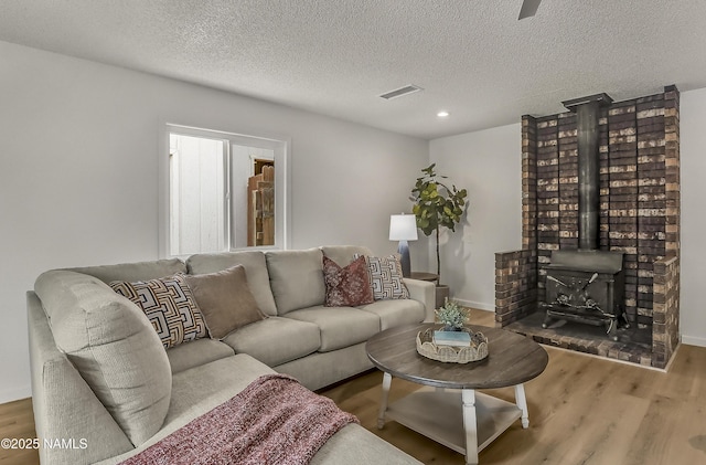 4972 E Snow Shoe Way, Flagstaff, AZ 86004 - living area with wood finished floors, a textured ceiling, recessed lighting, a wood stove, and baseboards