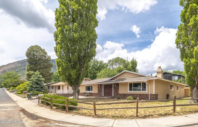 4972 E Snow Shoe Way, Flagstaff, AZ 86004 - ranch-style house featuring a fenced front yard, brick siding, and a chimney