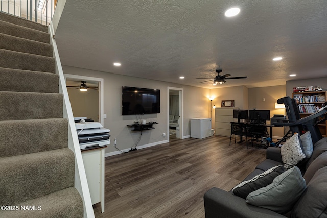 living room with hardwood / wood-style floors, ceiling fan, and a textured ceiling