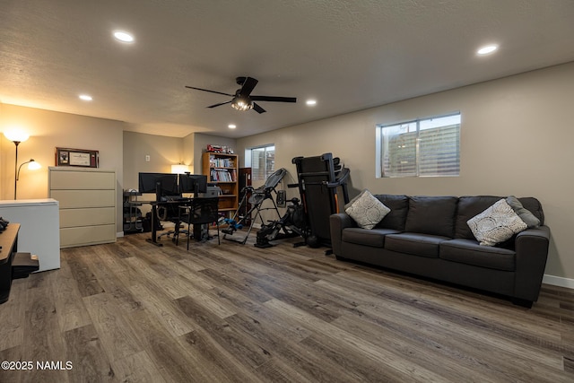 living room with hardwood / wood-style floors, a healthy amount of sunlight, ceiling fan, and a textured ceiling