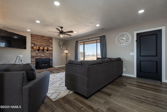 living room with ceiling fan, wood-type flooring, and a textured ceiling