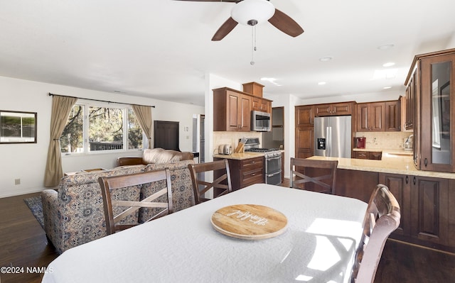 dining space with sink, dark wood-type flooring, and ceiling fan