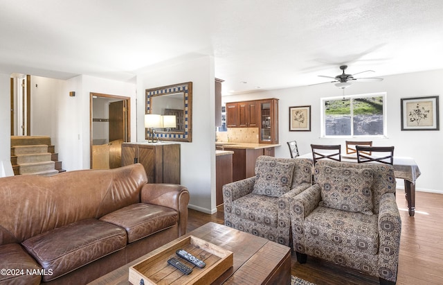 living room with ceiling fan and dark wood-type flooring