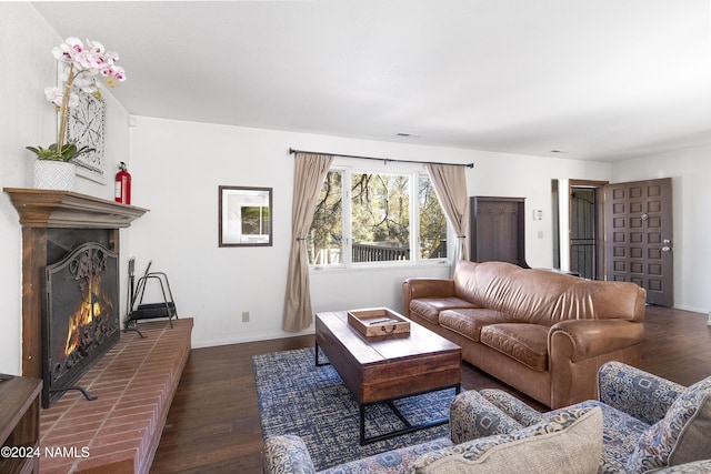 living room featuring dark wood-type flooring and a fireplace