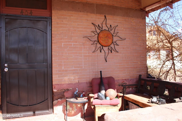 doorway to property with brick siding