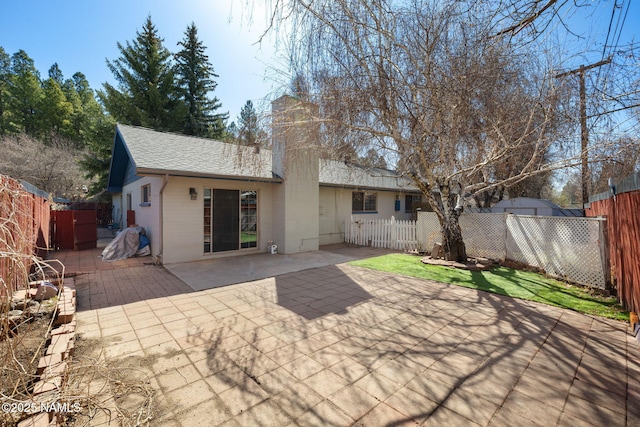 1707 N Fort Valley Rd, Flagstaff, AZ 86001 - rear view of house featuring roof with shingles, a chimney, a patio area, and fence private yard