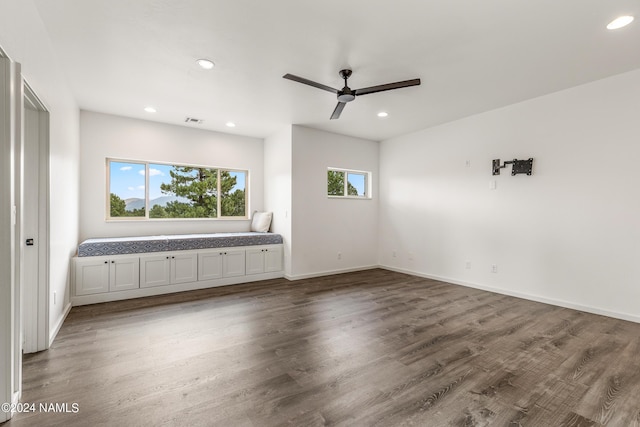 unfurnished living room featuring dark hardwood / wood-style floors and ceiling fan