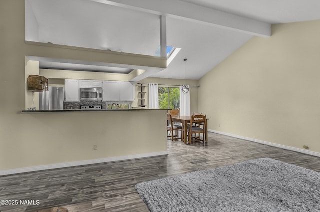4316 E Broken Rock Loop, Flagstaff, AZ 86004 - kitchen with appliances with stainless steel finishes, dark countertops, dark wood finished floors, white cabinetry, and baseboards