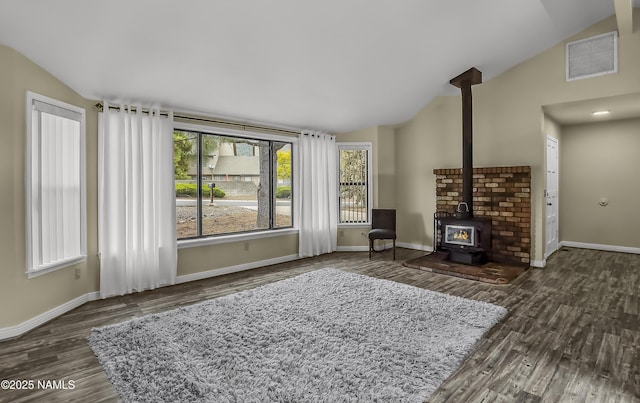 4316 E Broken Rock Loop, Flagstaff, AZ 86004 - living room with lofted ceiling, a wood stove, wood finished floors, and baseboards