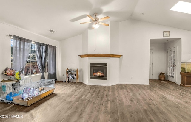 3366 Toho Trl, Flagstaff, AZ 86005 - living room featuring ceiling fan, visible vents, a lit fireplace, and wood finished floors