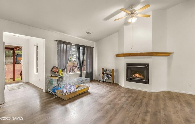 3366 Toho Trl, Flagstaff, AZ 86005 - living room with ceiling fan, a wealth of natural light, a warm lit fireplace, and wood finished floors