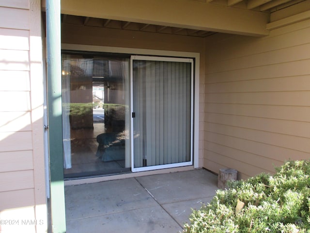 view of exterior entry featuring a patio area