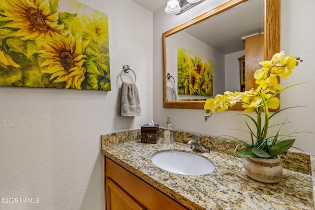 bathroom featuring a textured wall and vanity