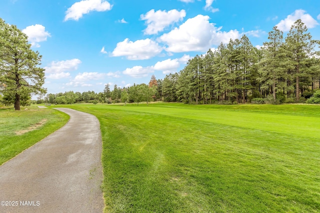 view of property's community featuring a lawn and view of golf course