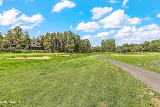 surrounding community with a yard and view of golf course