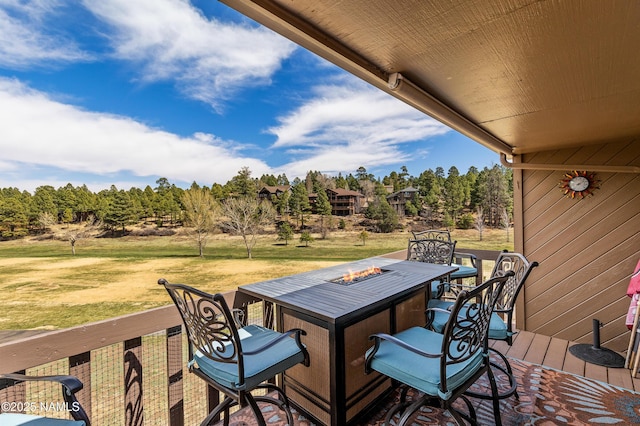 wooden deck with a yard and an outdoor fire pit