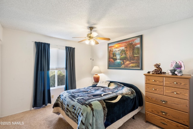 carpeted bedroom featuring a textured ceiling and ceiling fan