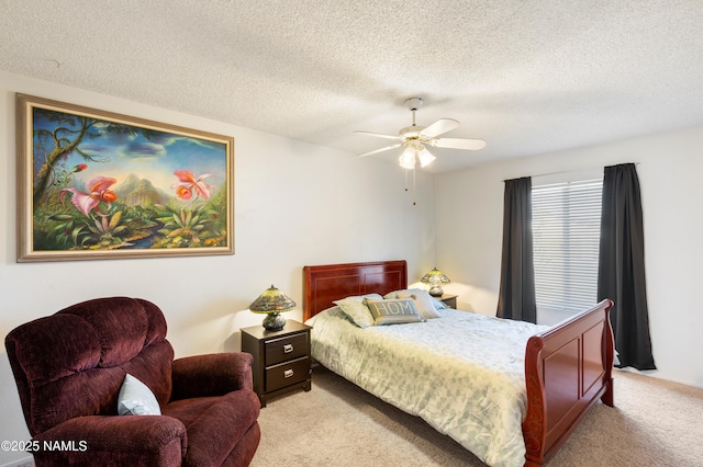 bedroom featuring ceiling fan, light colored carpet, and a textured ceiling