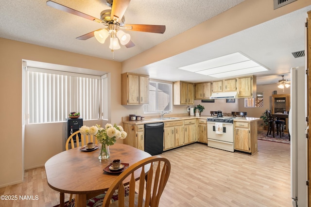 kitchen with under cabinet range hood, ceiling fan, light countertops, dishwasher, and white gas range