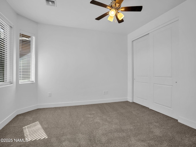 unfurnished bedroom with ceiling fan, carpet floors, and a closet