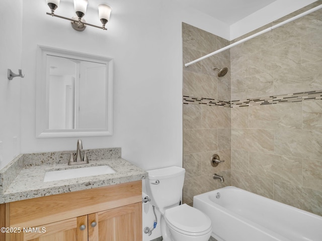 full bathroom featuring tiled shower / bath combo, toilet, and vanity