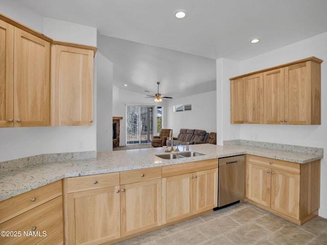 kitchen featuring light stone counters, stainless steel dishwasher, light brown cabinets, sink, and kitchen peninsula