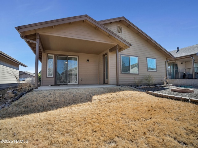 back of house featuring a patio and a fire pit