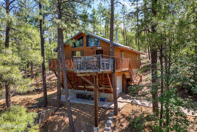 back of property featuring a garage and a deck