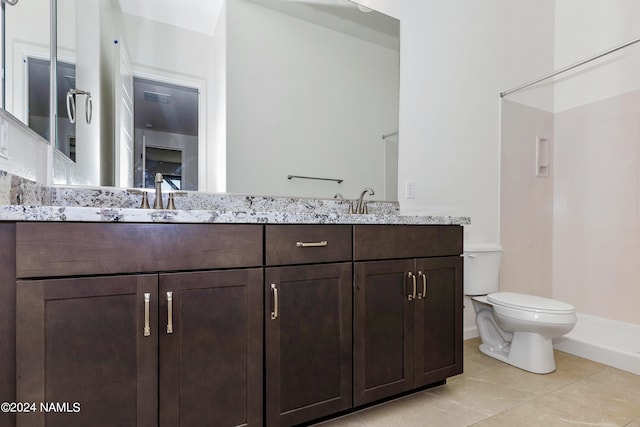 bathroom featuring toilet, vanity, walk in shower, and tile patterned flooring