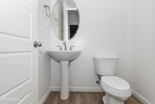 bathroom with toilet and hardwood / wood-style flooring