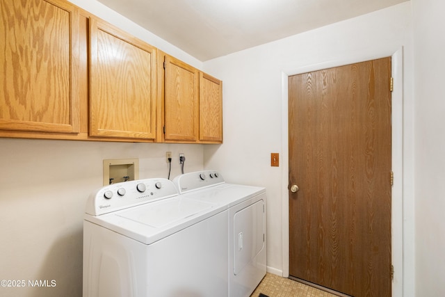 clothes washing area with separate washer and dryer and cabinet space