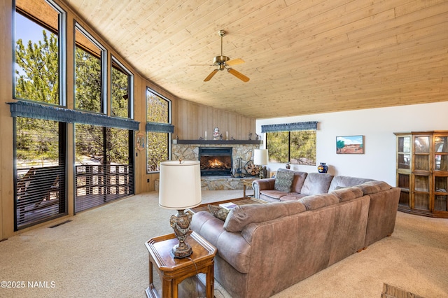 living room featuring wooden ceiling, ceiling fan, a stone fireplace, and carpet floors