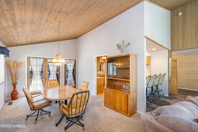 dining area with a healthy amount of sunlight, wood ceiling, carpet, and vaulted ceiling